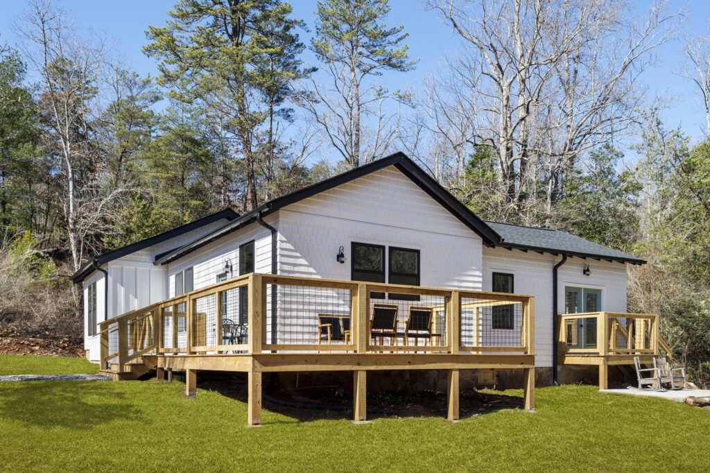 Modern home with a wooden deck and a forest backdrop