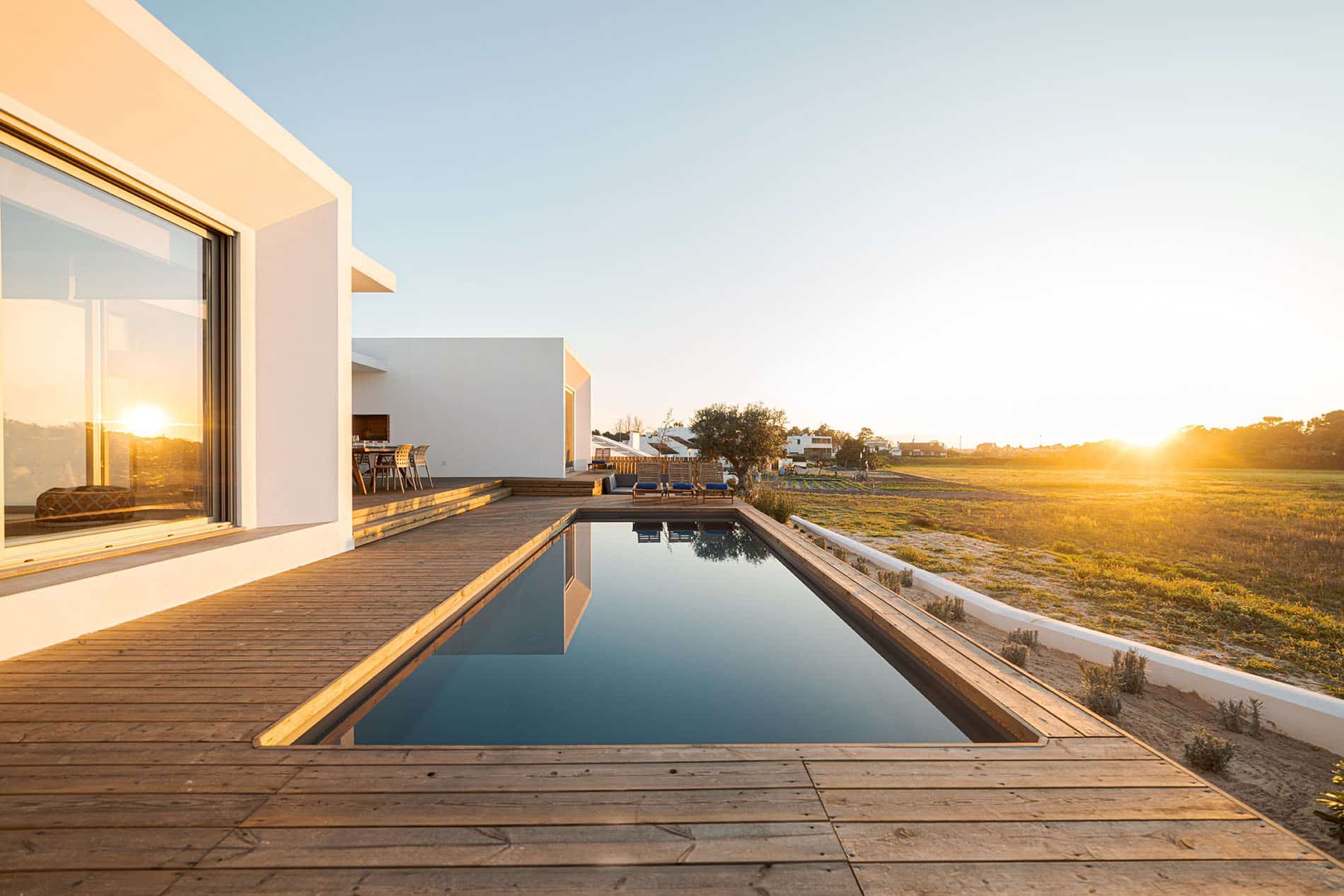 Modern home with a pool at sunset