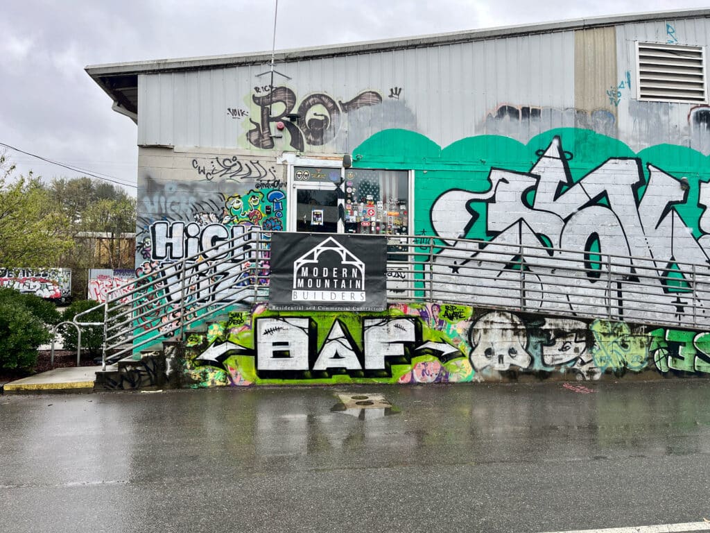 Graffiti-covered building with a construction company sign